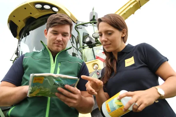 Man and woman looking at envelope of Josilac inoculants 